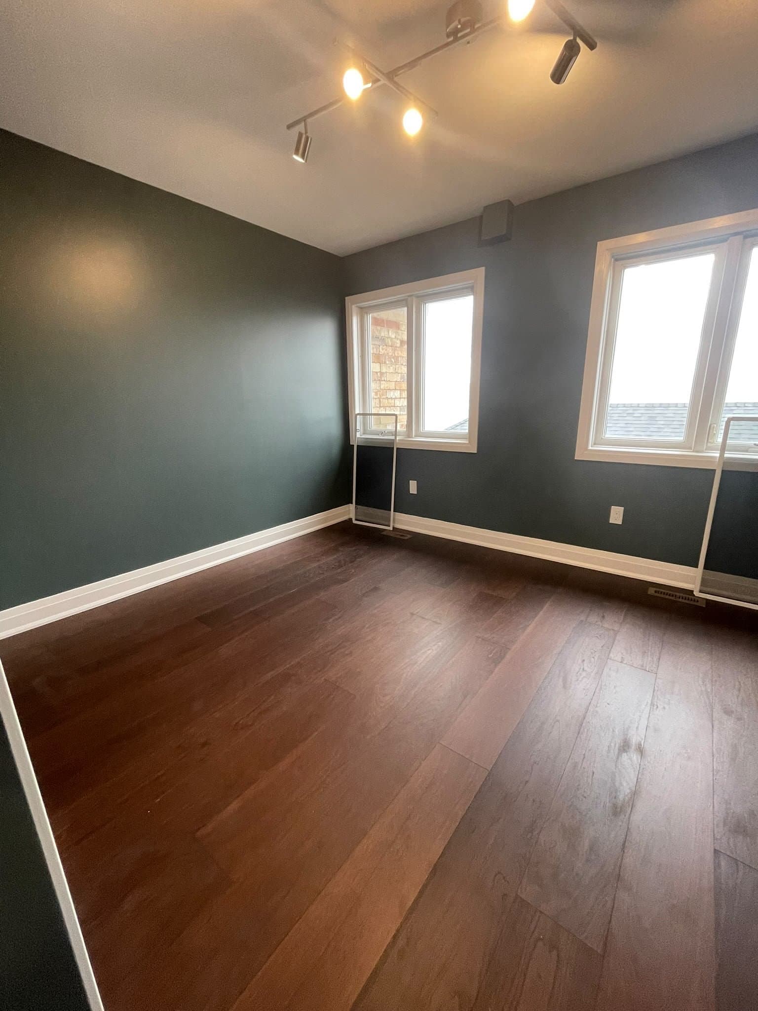 Bedroom with dark green walls and new hardwood flooring