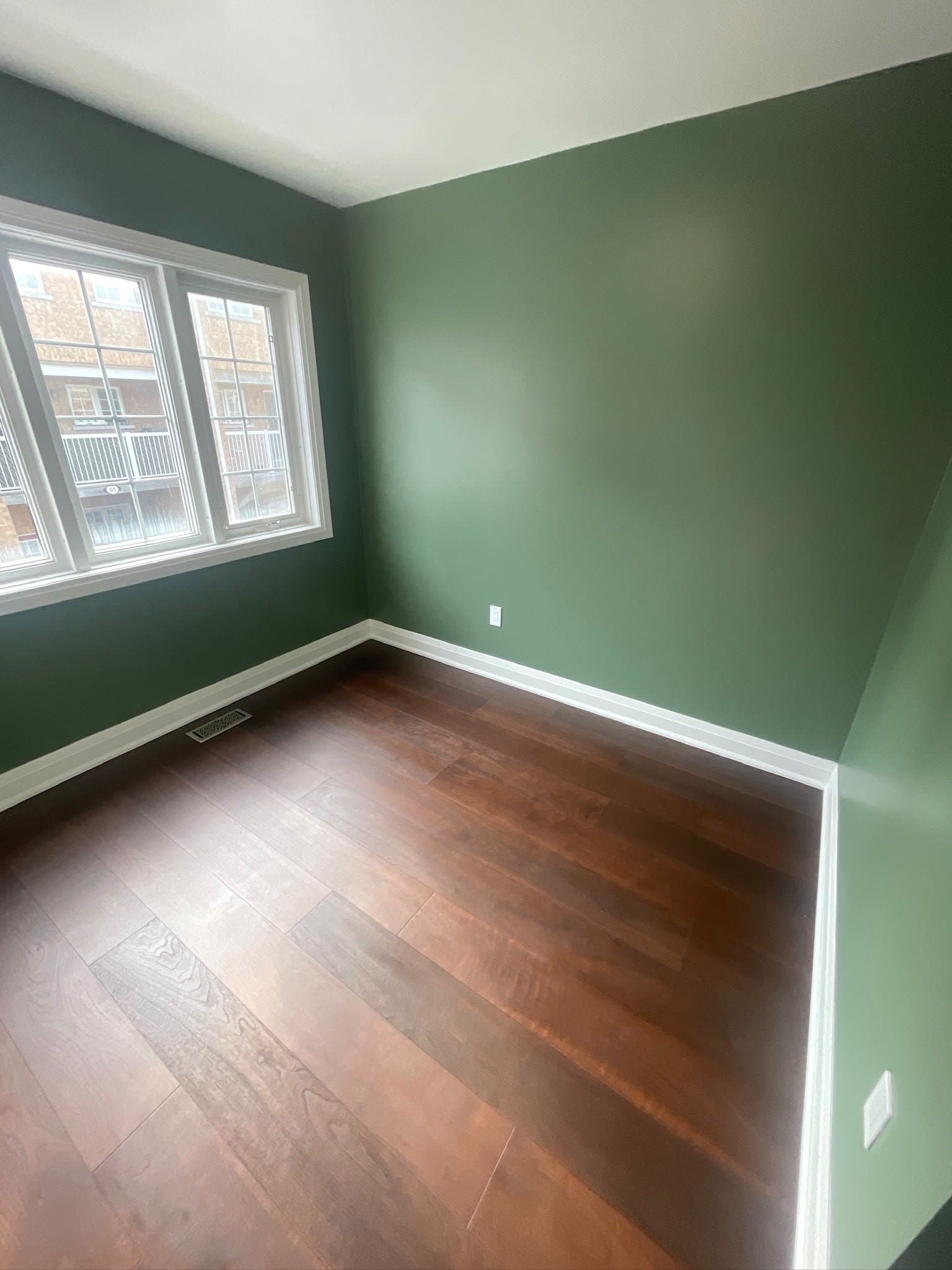 Renovated bedroom with green walls and large window