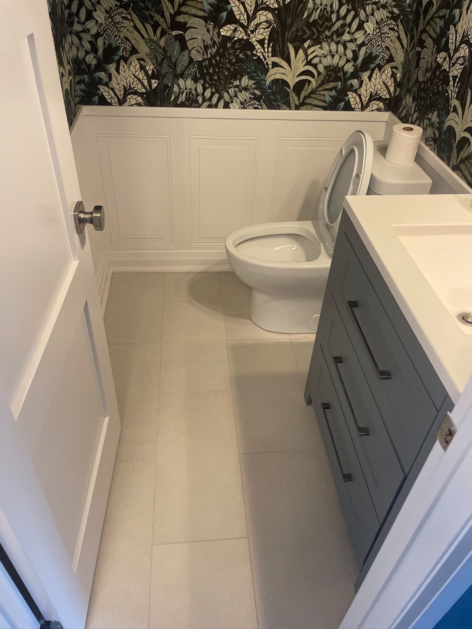 Powder room with patterned wallpaper and wainscoting
