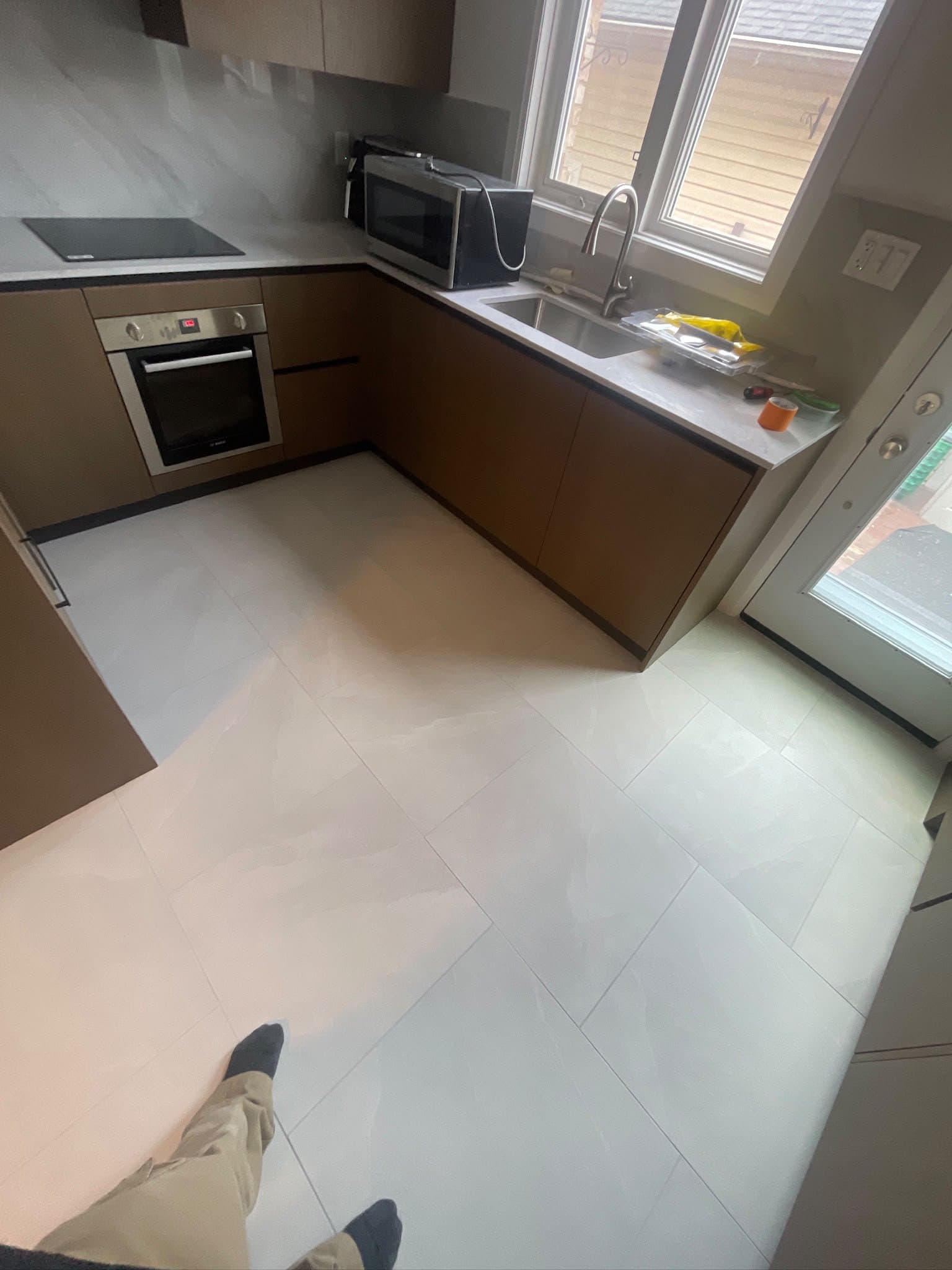 Kitchen renovation in progress with new tile and cabinetry