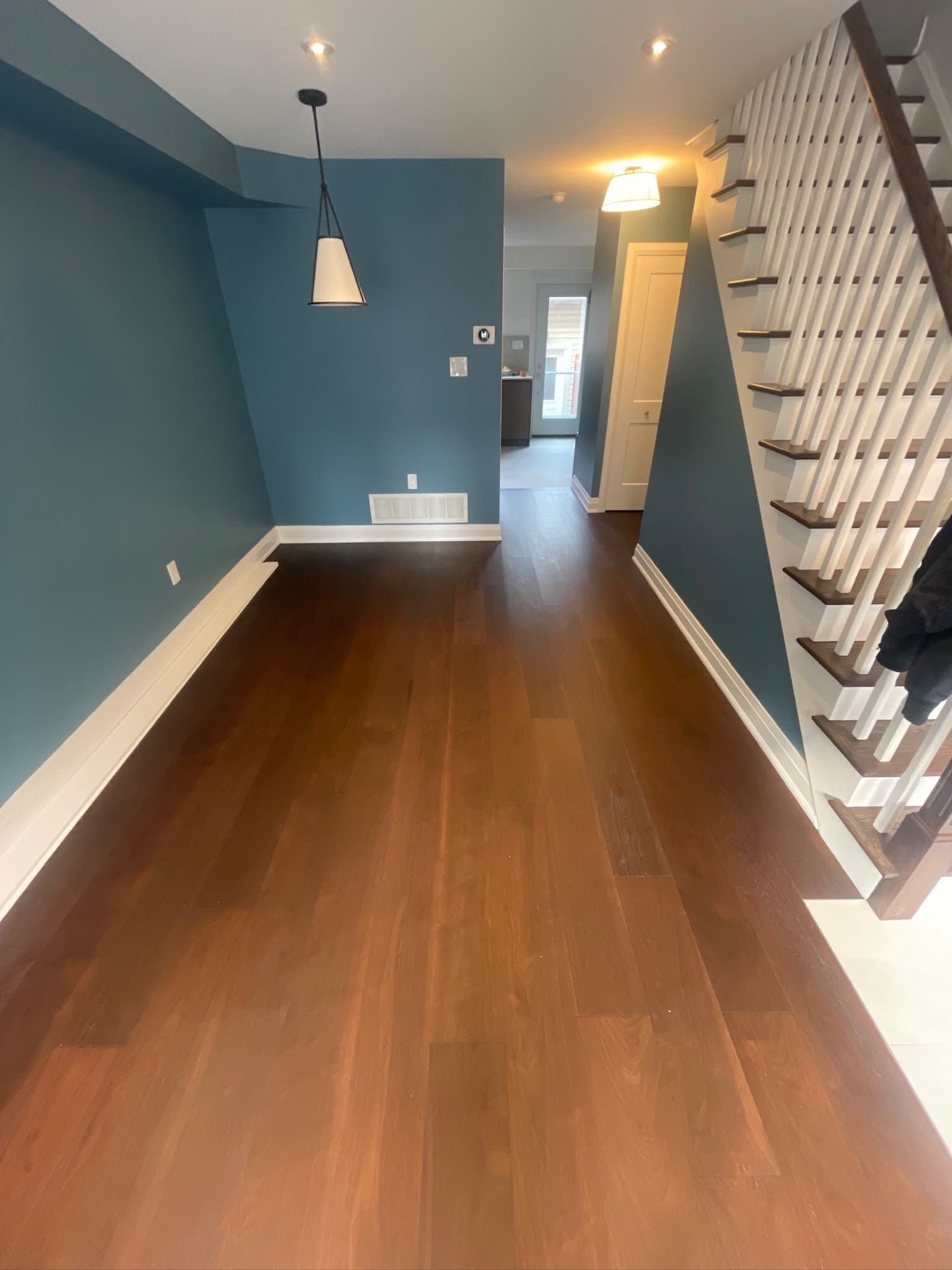 Renovated hallway with blue walls leading to staircase