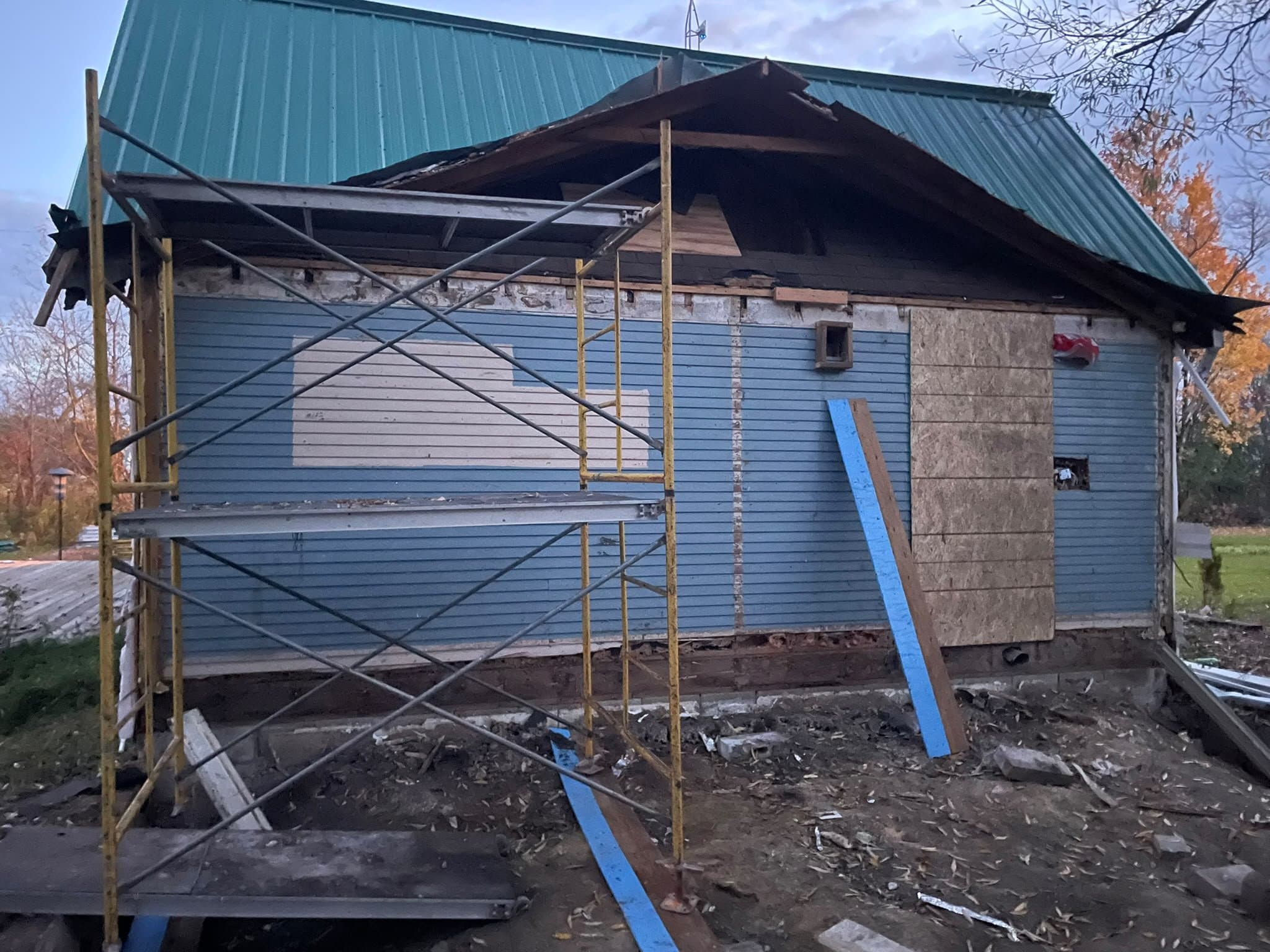 Exterior renovation in progress with scaffolding and new siding