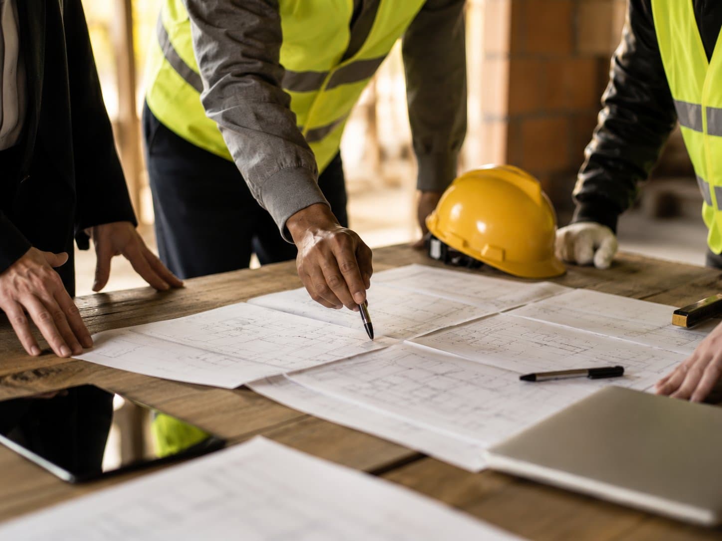 Contractor and homeowner reviewing blueprints on-site during a renovation project